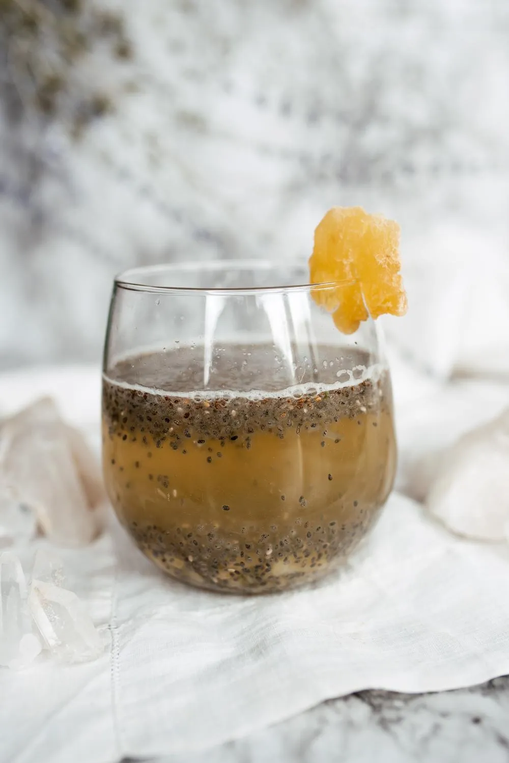 a glass with chia seed ginger water and garnish on a marble backdrop