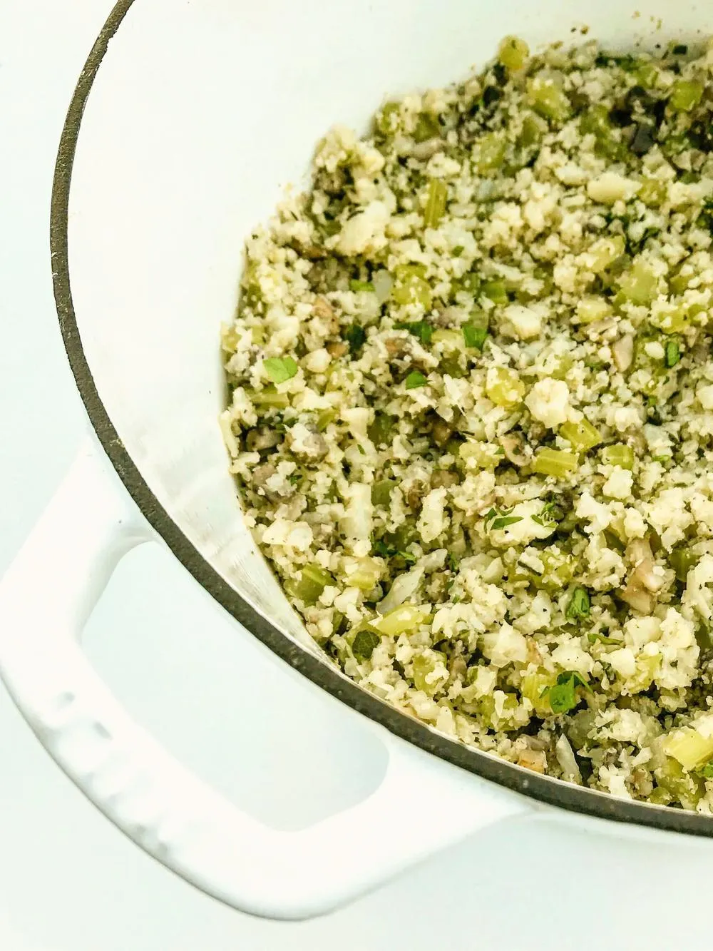a big pot full of the ingredients for grain free thanksgiving stuffing like chopped cauliflower and celery
