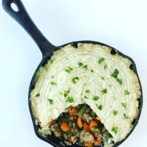 a cast iron skillet full of shepard&#x27;s pie, topped with fresh chopped parsley