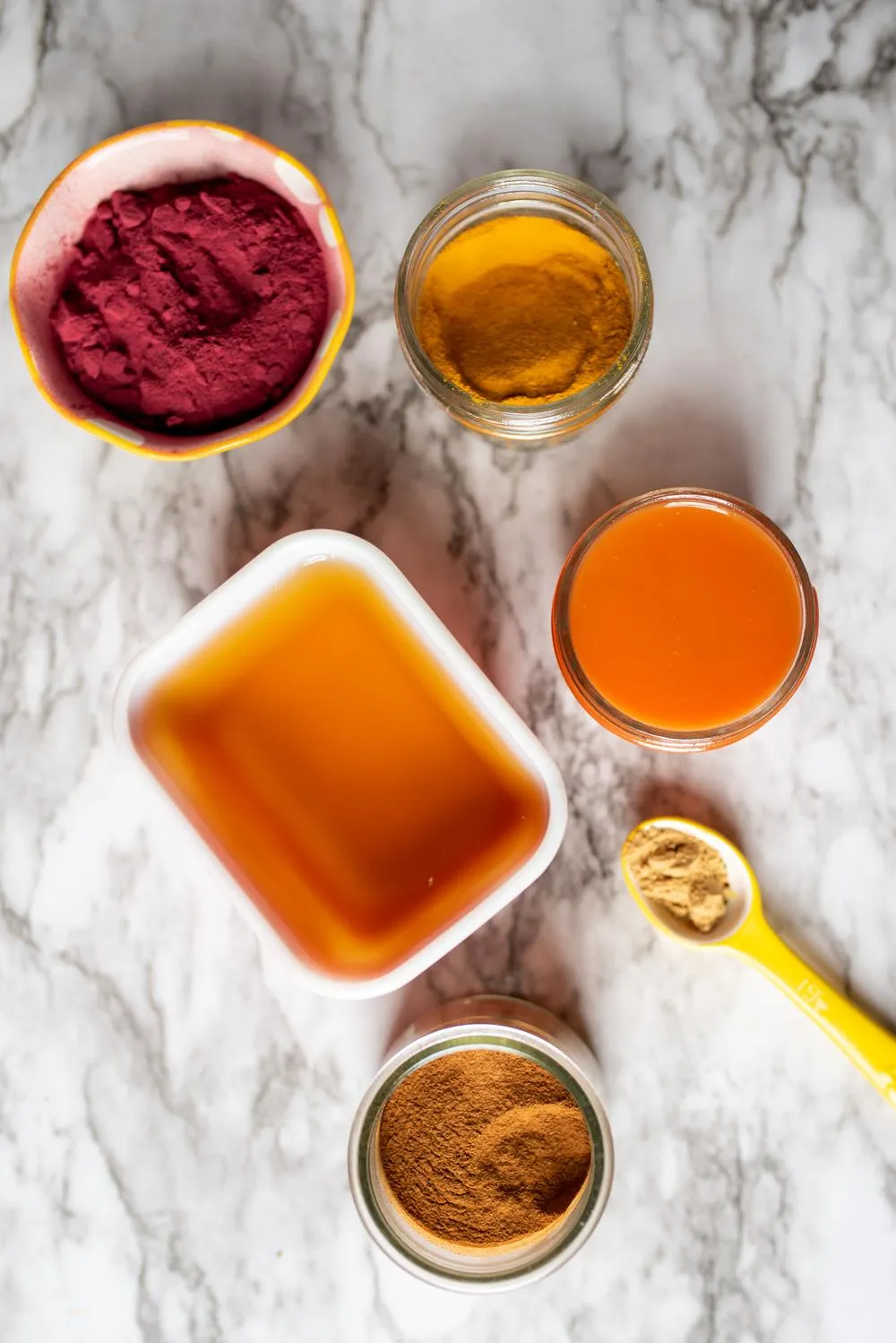 small bowls of colorful powders on a marble table