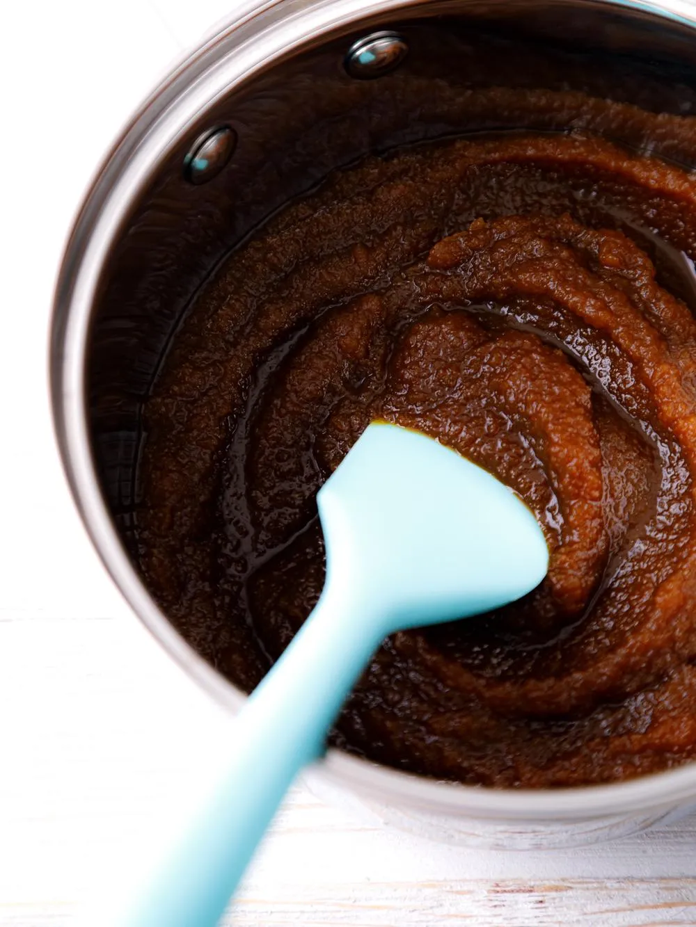 a saucepan of tomato free bbq sauce with a blue spatula inside